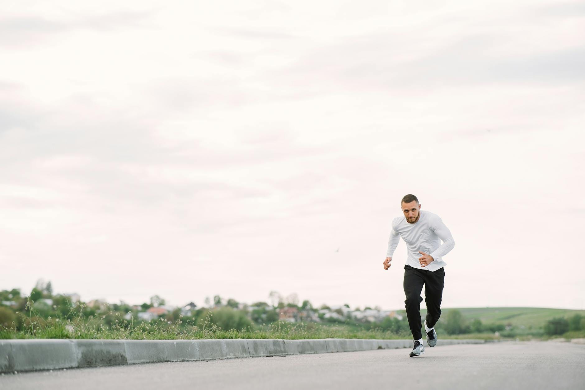 A man in sportswear jogging on a road, showcasing outdoor fitness.