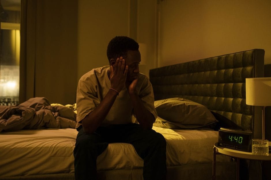 A tired man lying awake in bed at night